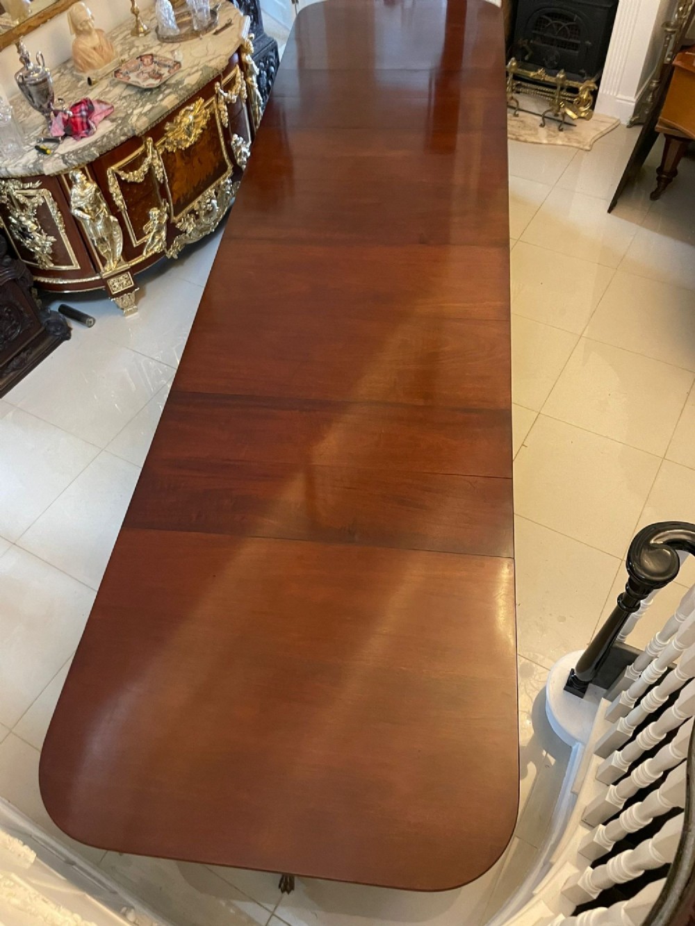 An exceptionally long mahogany banquet dining table supported on four turned pedestals with splayed legs and brass castors. View XV