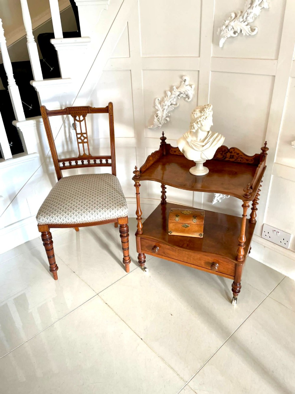 An antique Victorian burr walnut two-tier lamp table featuring a decorative floral inlaid gallery, turned finials, spiral columns, a single drawer, and brass castors. View XI