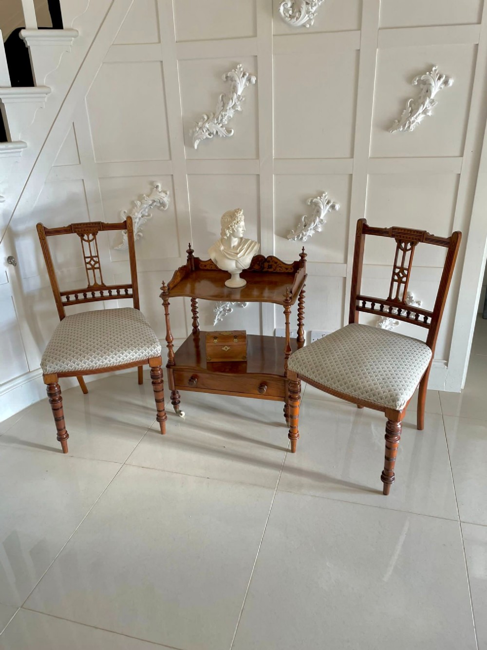 An antique Victorian burr walnut two-tier lamp table featuring a decorative floral inlaid gallery, turned finials, spiral columns, a single drawer, and brass castors. View XII