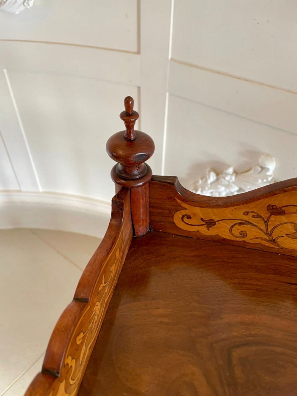 An antique Victorian burr walnut two-tier lamp table featuring a decorative floral inlaid gallery, turned finials, spiral columns, a single drawer, and brass castors. View XIV
