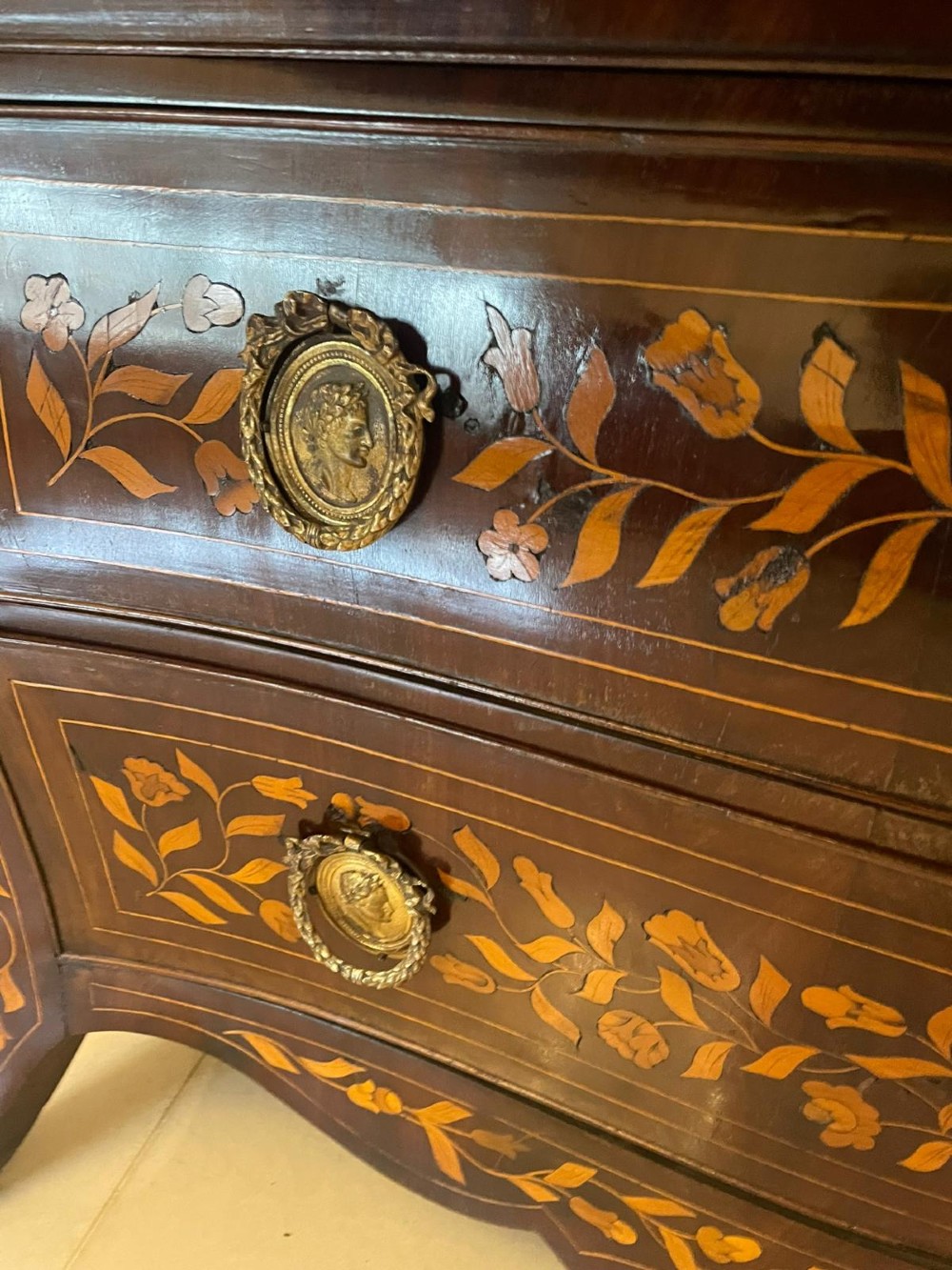 An 18th-century mahogany cylinder bureau decorated with detailed floral marquetry inlay across the curved roll-top and three lower drawers. View II