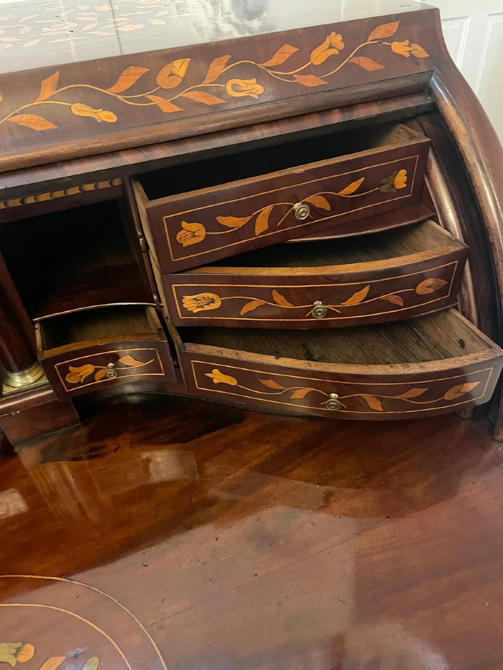 An 18th-century mahogany cylinder bureau decorated with detailed floral marquetry inlay across the curved roll-top and three lower drawers. View III