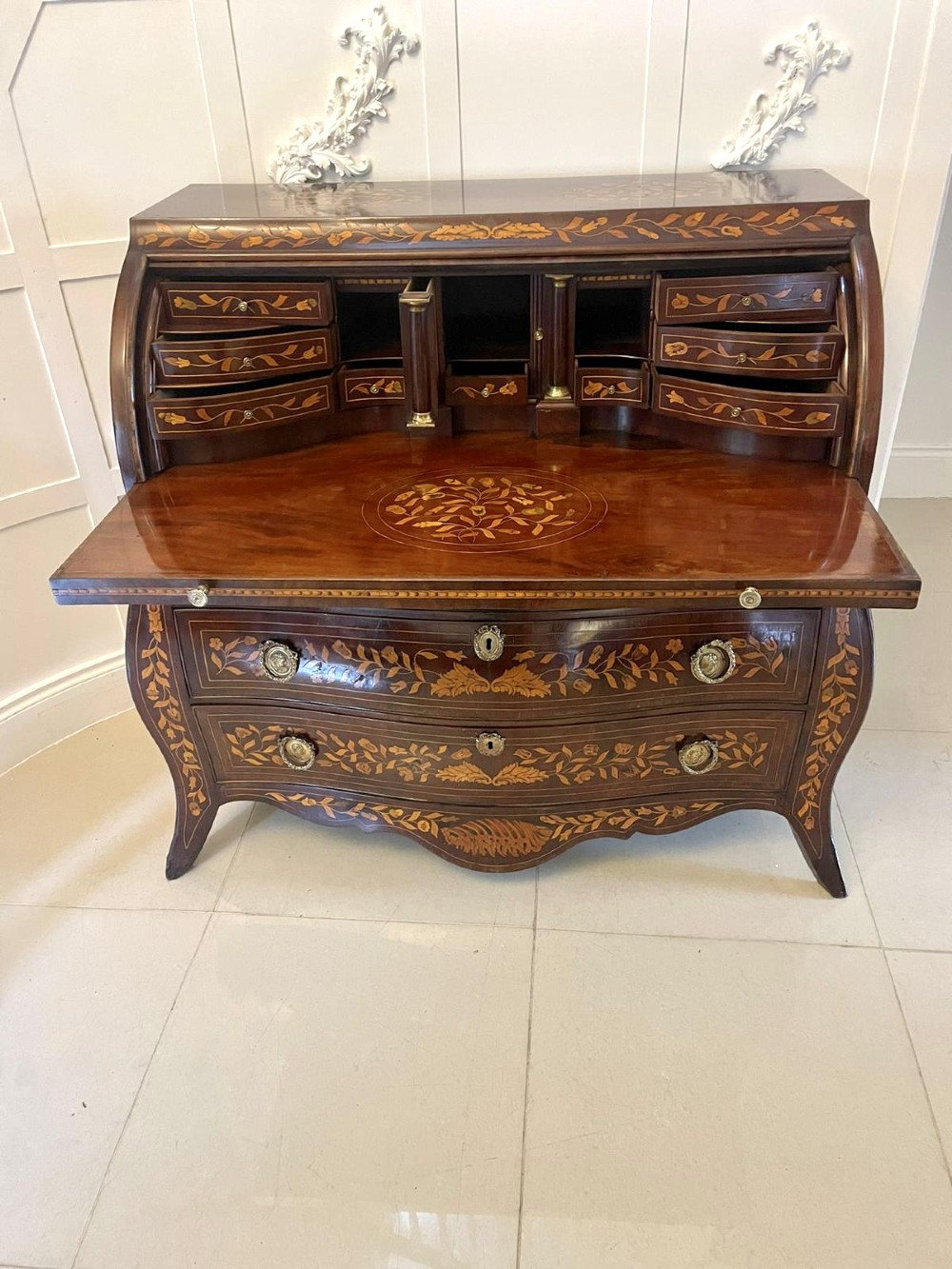 An 18th-century mahogany cylinder bureau decorated with detailed floral marquetry inlay across the curved roll-top and three lower drawers. View VIII