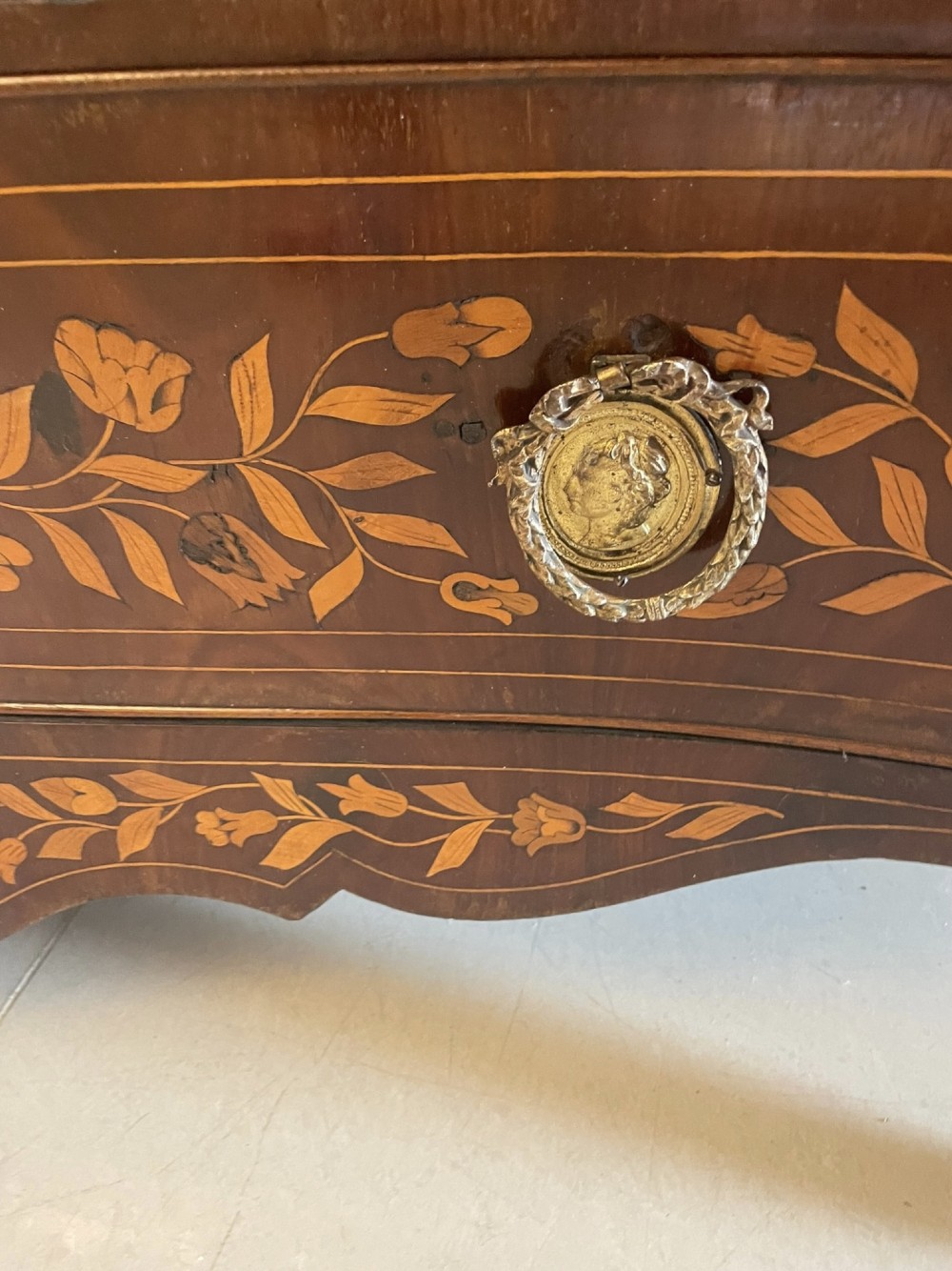 An 18th-century mahogany cylinder bureau decorated with detailed floral marquetry inlay across the curved roll-top and three lower drawers. View XI