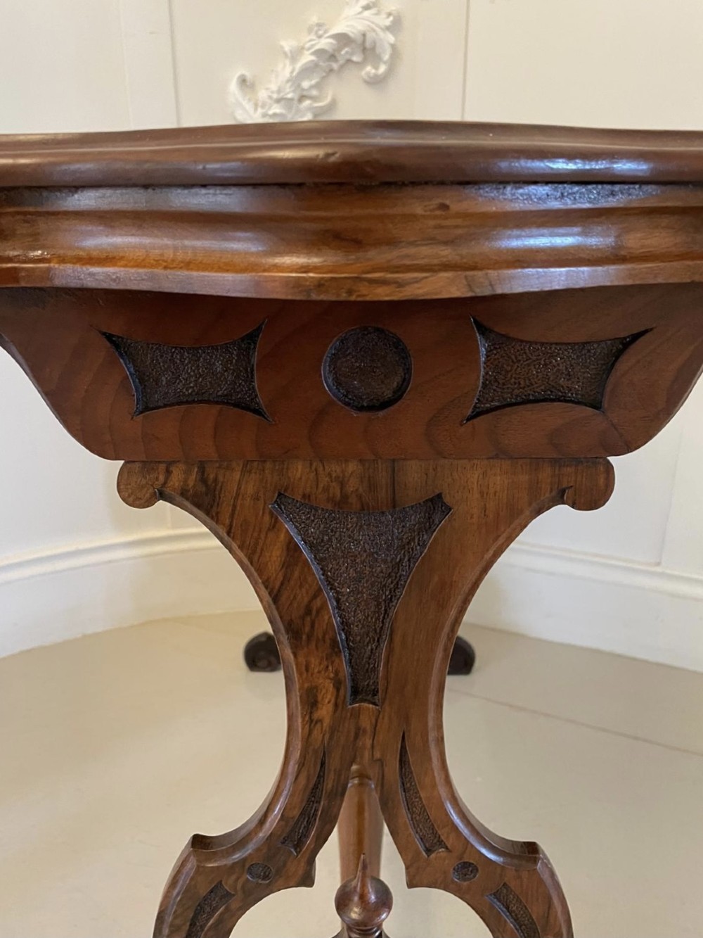 A Victorian burr walnut centre table with a serpentine shaped top, resting on carved pierced end supports and connected by a turned stretcher. View VIII
