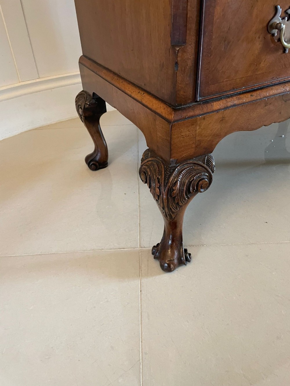 An antique burr walnut chest on stand featuring a two-door cupboard with arched panels above three long drawers, resting on carved cabriole legs. View II