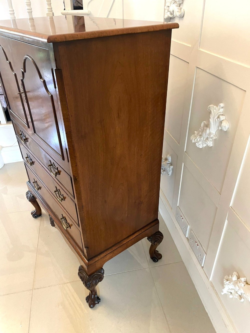 An antique burr walnut chest on stand featuring a two-door cupboard with arched panels above three long drawers, resting on carved cabriole legs. View III