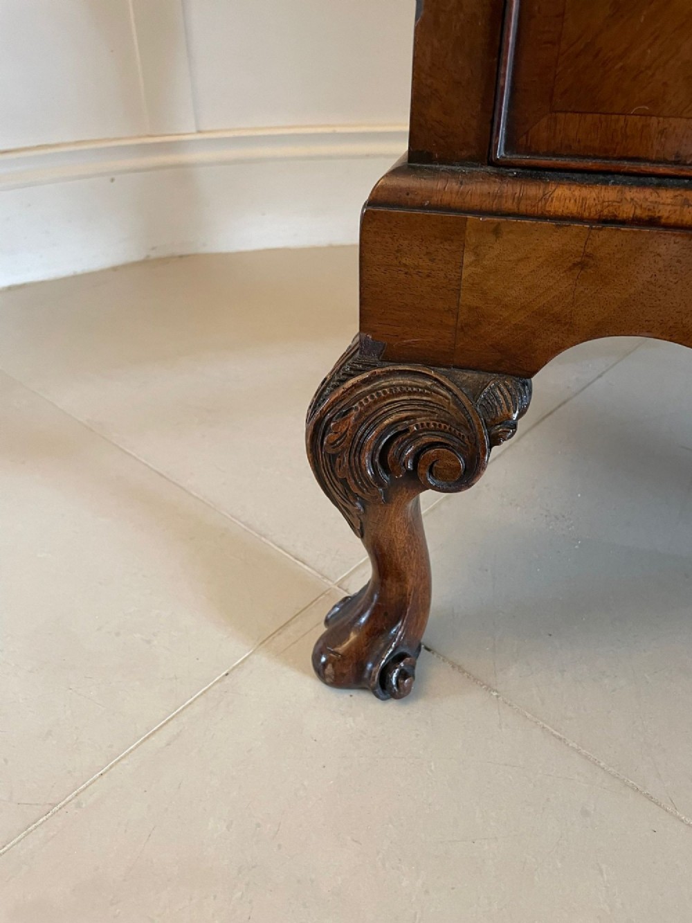 An antique burr walnut chest on stand featuring a two-door cupboard with arched panels above three long drawers, resting on carved cabriole legs. View VIII