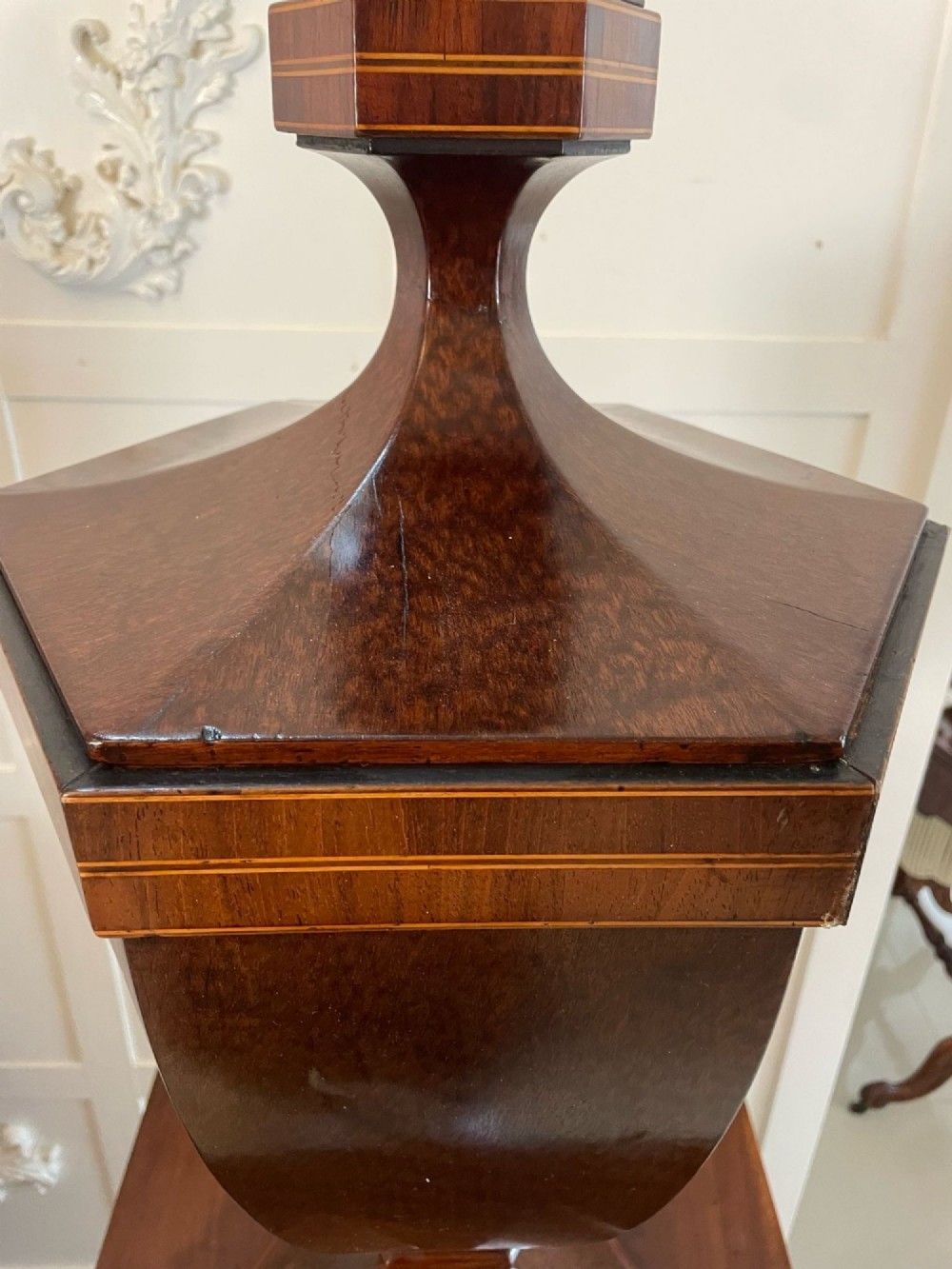 A pair of George III mahogany wine urns featuring flame mahogany oval inlay panels resting atop matching square pedestal cupboards with brass spigots. View VI