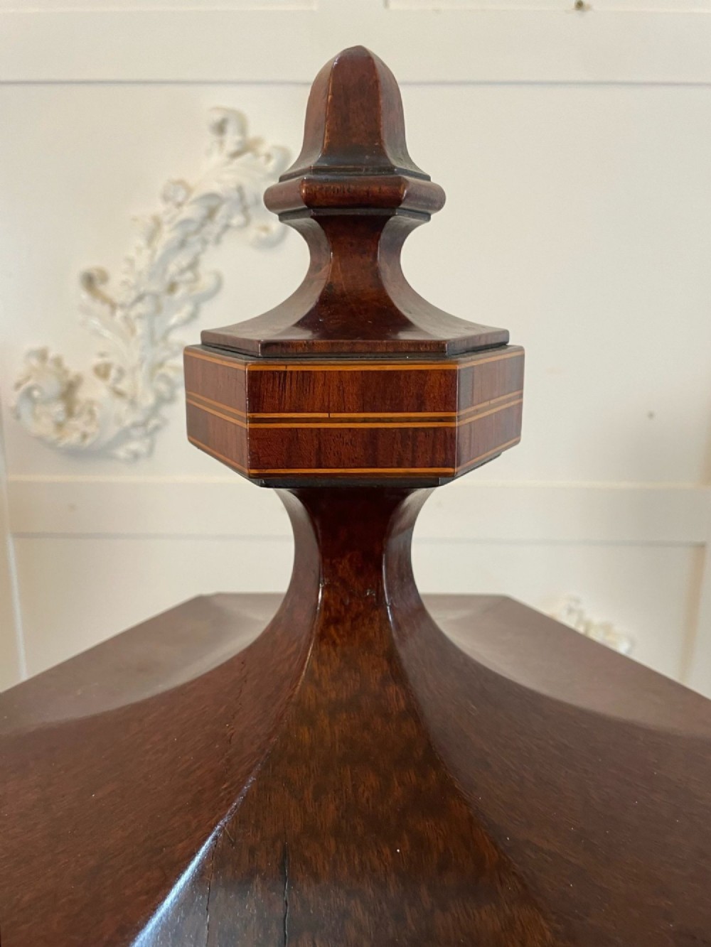A pair of George III mahogany wine urns featuring flame mahogany oval inlay panels resting atop matching square pedestal cupboards with brass spigots. View VII