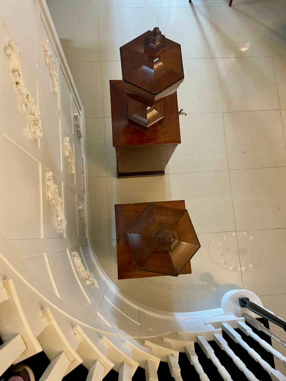 A pair of George III mahogany wine urns featuring flame mahogany oval inlay panels resting atop matching square pedestal cupboards with brass spigots. View XI