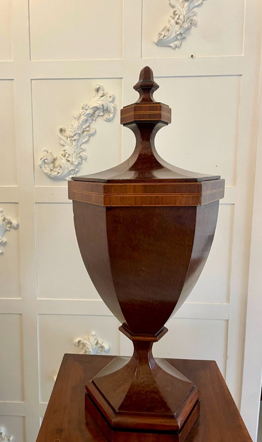 A pair of George III mahogany wine urns featuring flame mahogany oval inlay panels resting atop matching square pedestal cupboards with brass spigots. View XIII