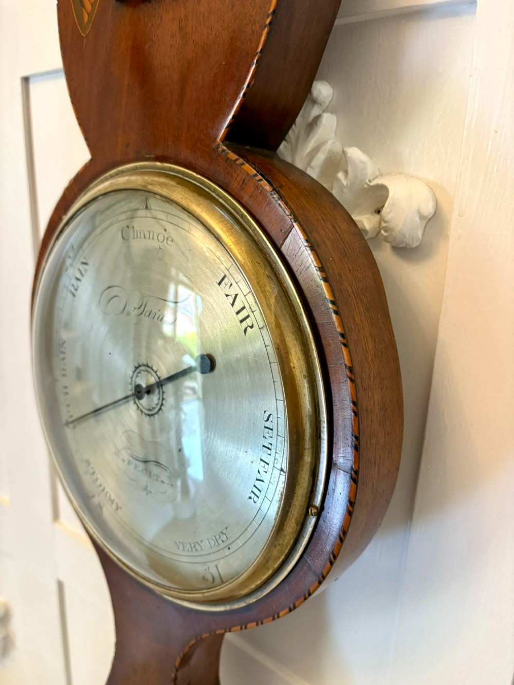 An antique George III mahogany banjo wall barometer featuring shell marquetry inlays, a silvered circular dial, an integrated mercury thermometer, and a broken-arch pediment with a brass finial. View II