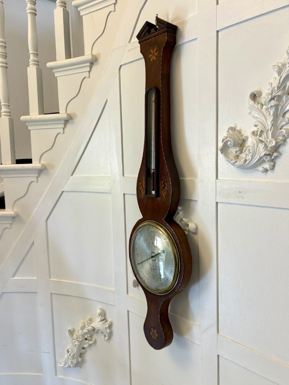 An antique George III mahogany banjo wall barometer featuring shell marquetry inlays, a silvered circular dial, an integrated mercury thermometer, and a broken-arch pediment with a brass finial. View VIII