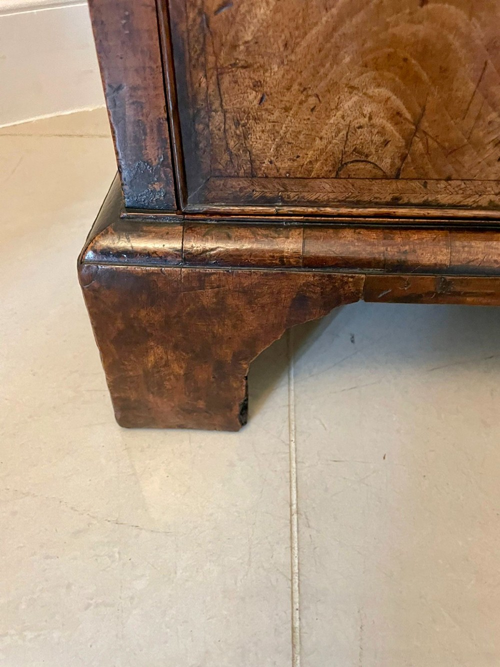 A George I period chest of drawers in figured walnut featuring two short drawers over three long drawers with brass drop handles and bracket feet. View XI