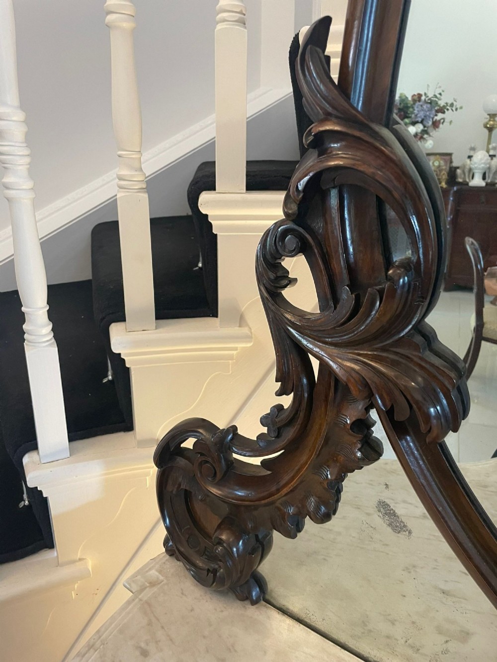A Victorian burr walnut credenza featuring a serpentine white marble top, mirrored cupboard doors, and a large oval mirror back with carved scrolling detail. View VI