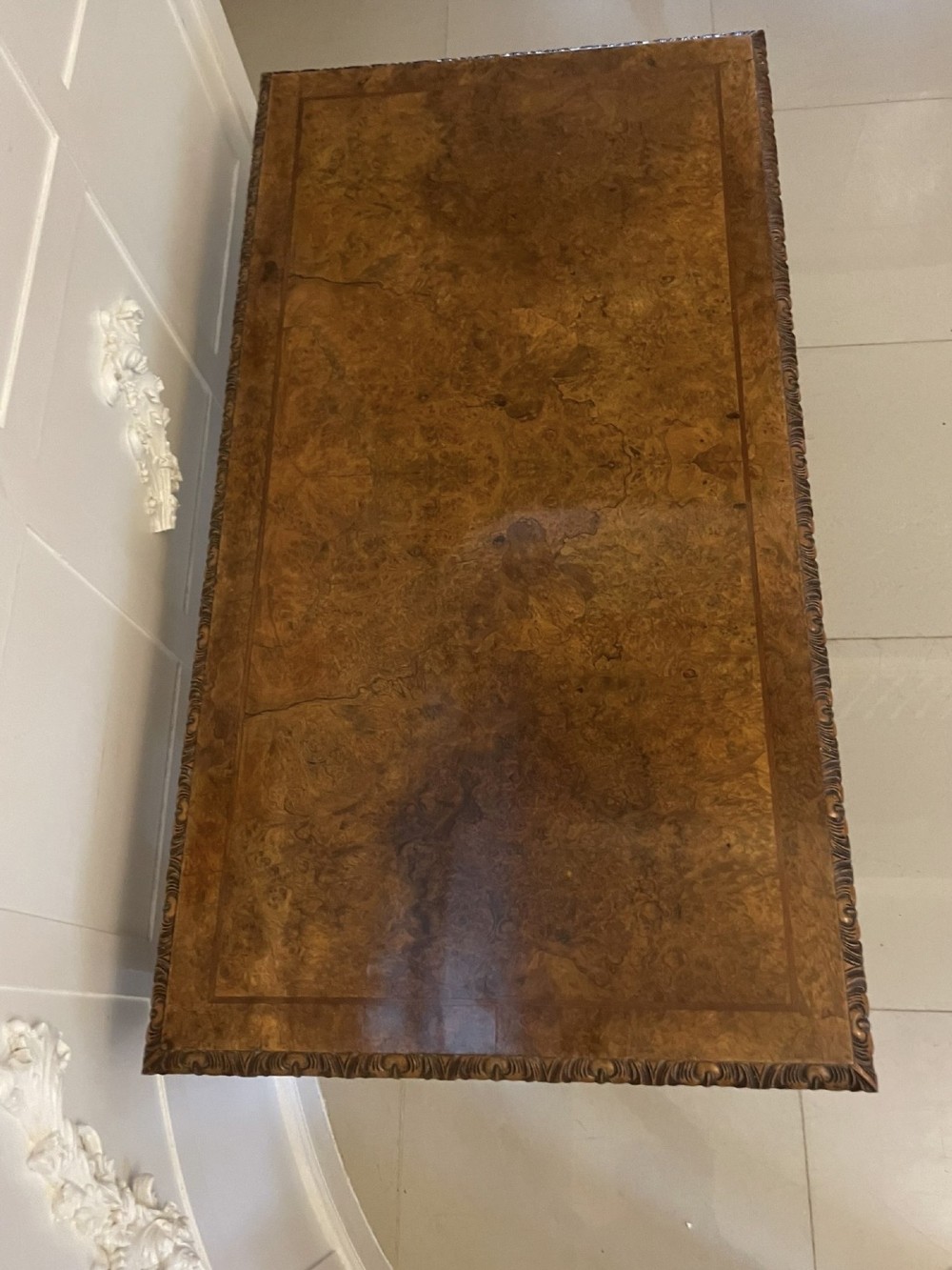 An antique burr walnut console table featuring two drawers, intricate carved moulding along the frame, and carved cabriole legs ending in claw feet. View XII