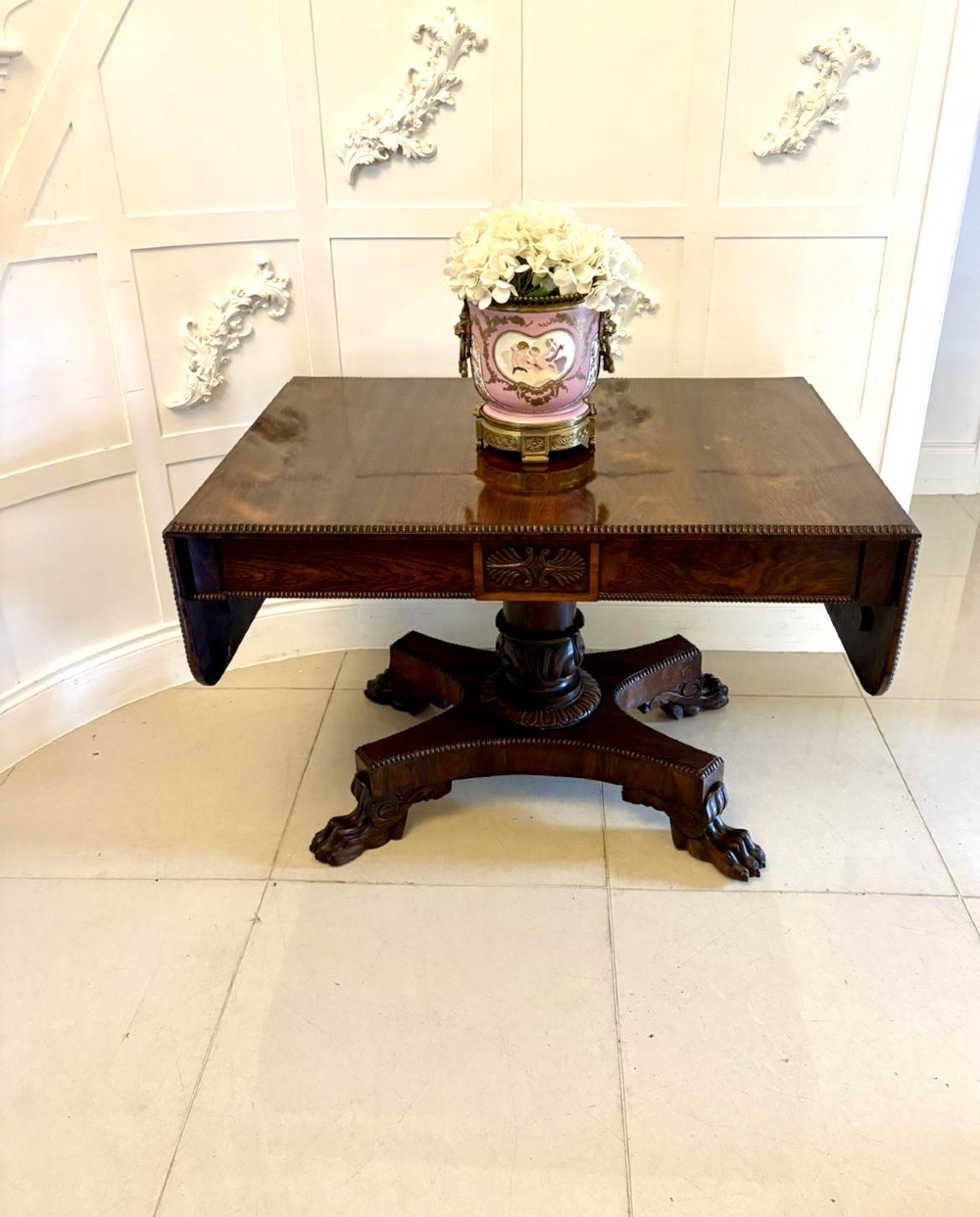 A Regency dark rosewood drop-leaf sofa table with a turned pedestal base and carved claw feet. View V