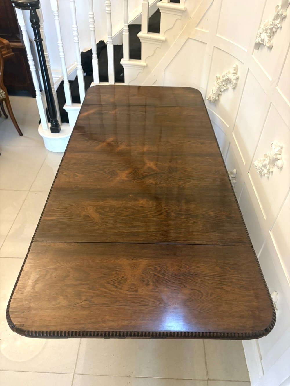 A Regency dark rosewood drop-leaf sofa table with a turned pedestal base and carved claw feet. View VI