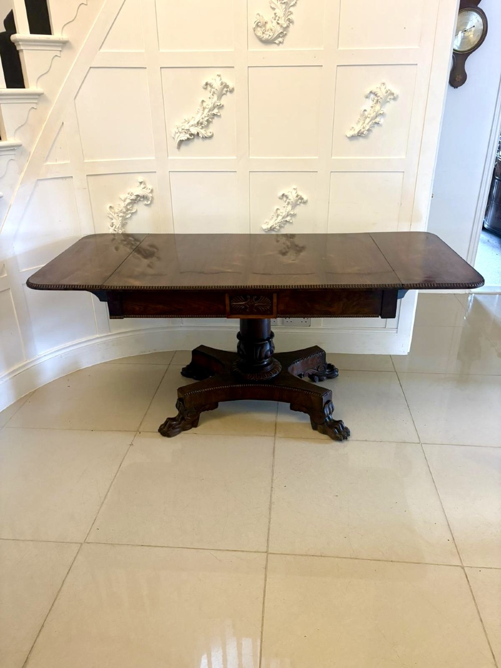 A Regency dark rosewood drop-leaf sofa table with a turned pedestal base and carved claw feet. View VII