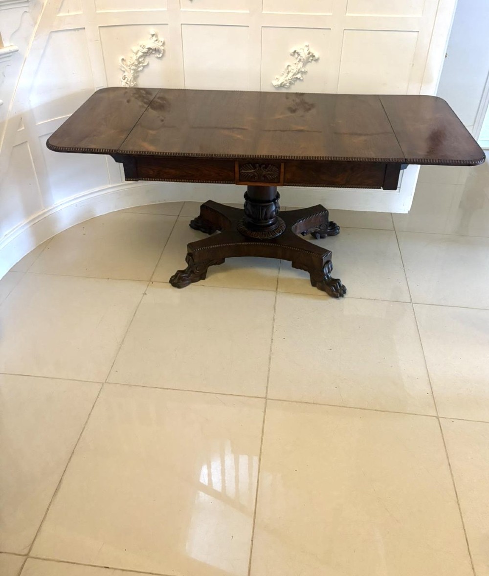 A Regency dark rosewood drop-leaf sofa table with a turned pedestal base and carved claw feet. View VIII