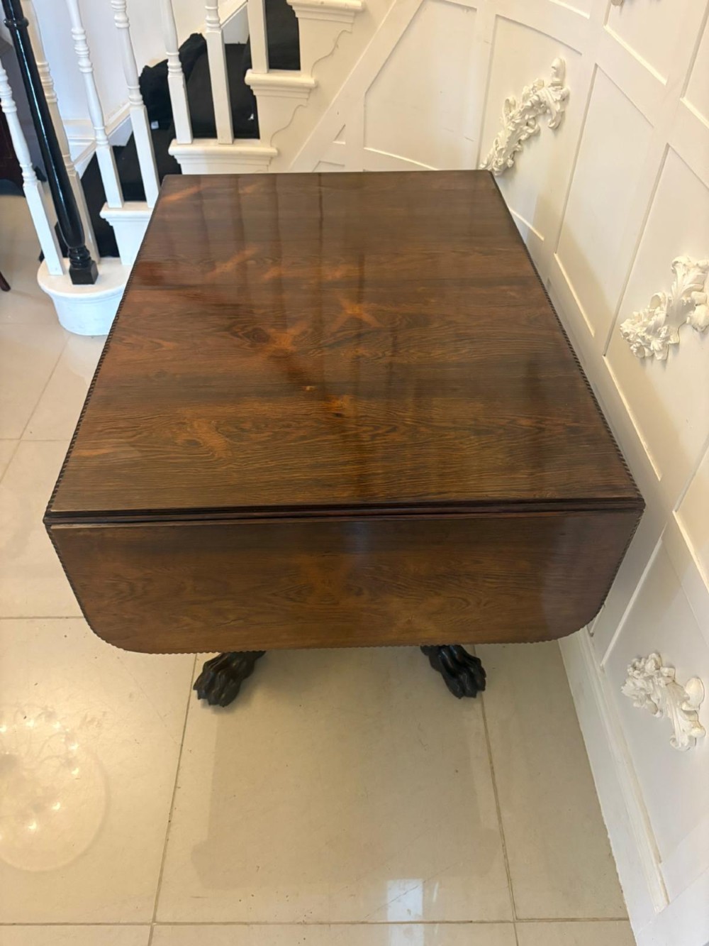 A Regency dark rosewood drop-leaf sofa table with a turned pedestal base and carved claw feet. View XI