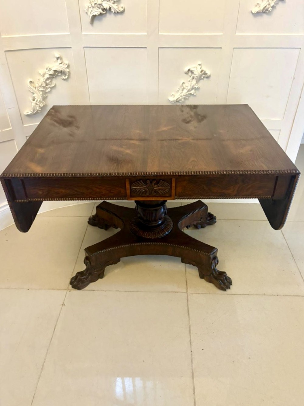 A Regency dark rosewood drop-leaf sofa table with a turned pedestal base and carved claw feet. View XIII