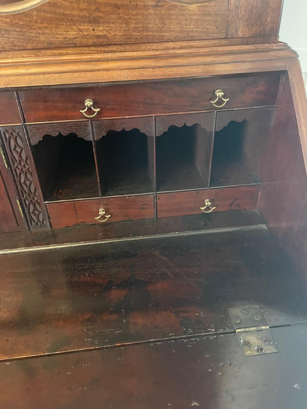 A George II figured mahogany bureau bookcase featuring shaped panel upper doors above a slant-front writing slope and four graduated drawers on bracket feet. View II