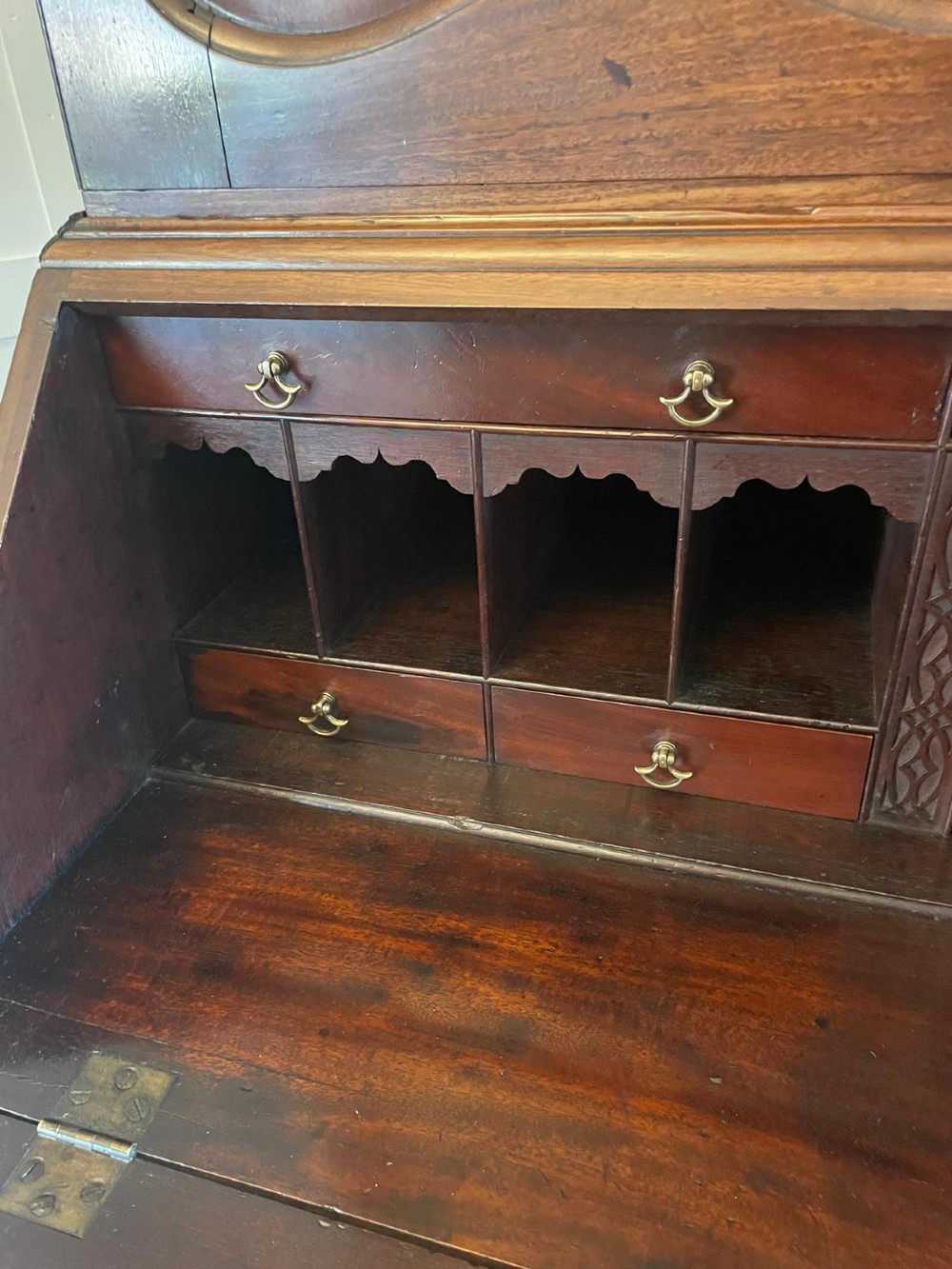 A George II figured mahogany bureau bookcase featuring shaped panel upper doors above a slant-front writing slope and four graduated drawers on bracket feet. View IV