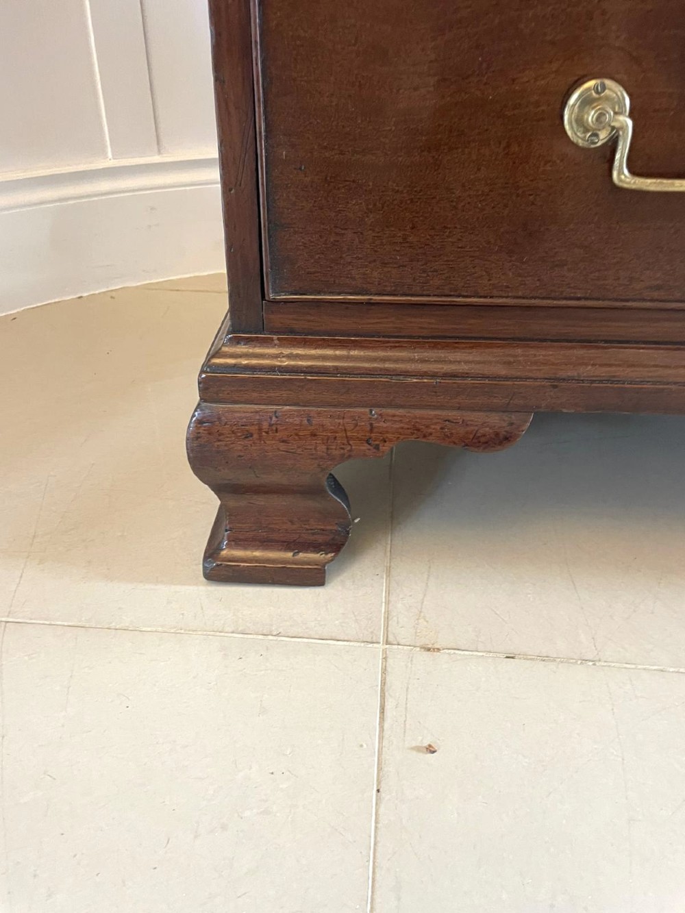 A George II figured mahogany bureau bookcase featuring shaped panel upper doors above a slant-front writing slope and four graduated drawers on bracket feet. View XI