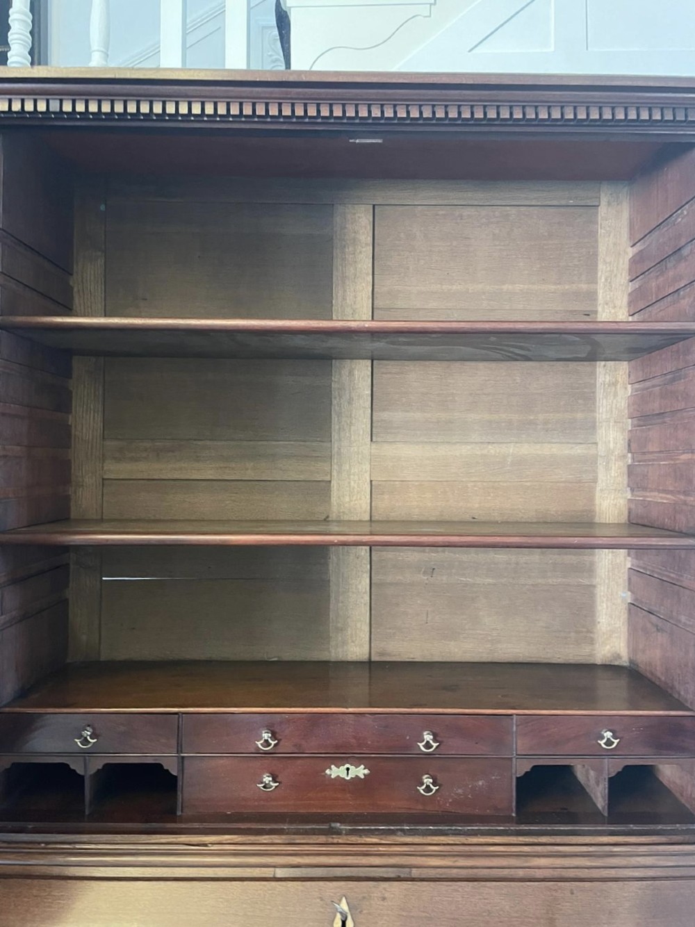 A George II figured mahogany bureau bookcase featuring shaped panel upper doors above a slant-front writing slope and four graduated drawers on bracket feet. View XIV