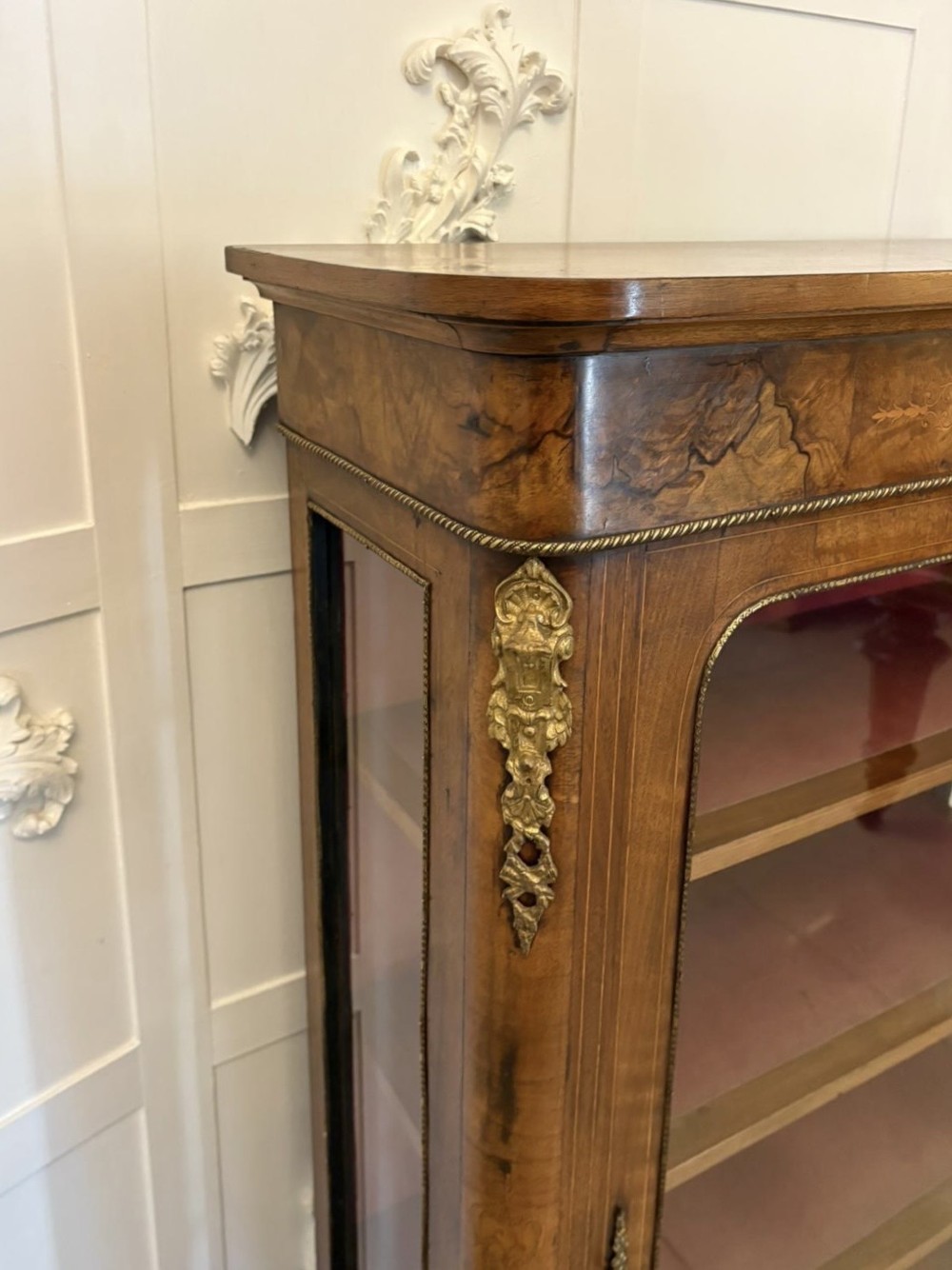 A Victorian burr walnut pier cabinet featuring a single glazed door, floral marquetry along the frieze, and gilt ormolu corner mounts. View XI