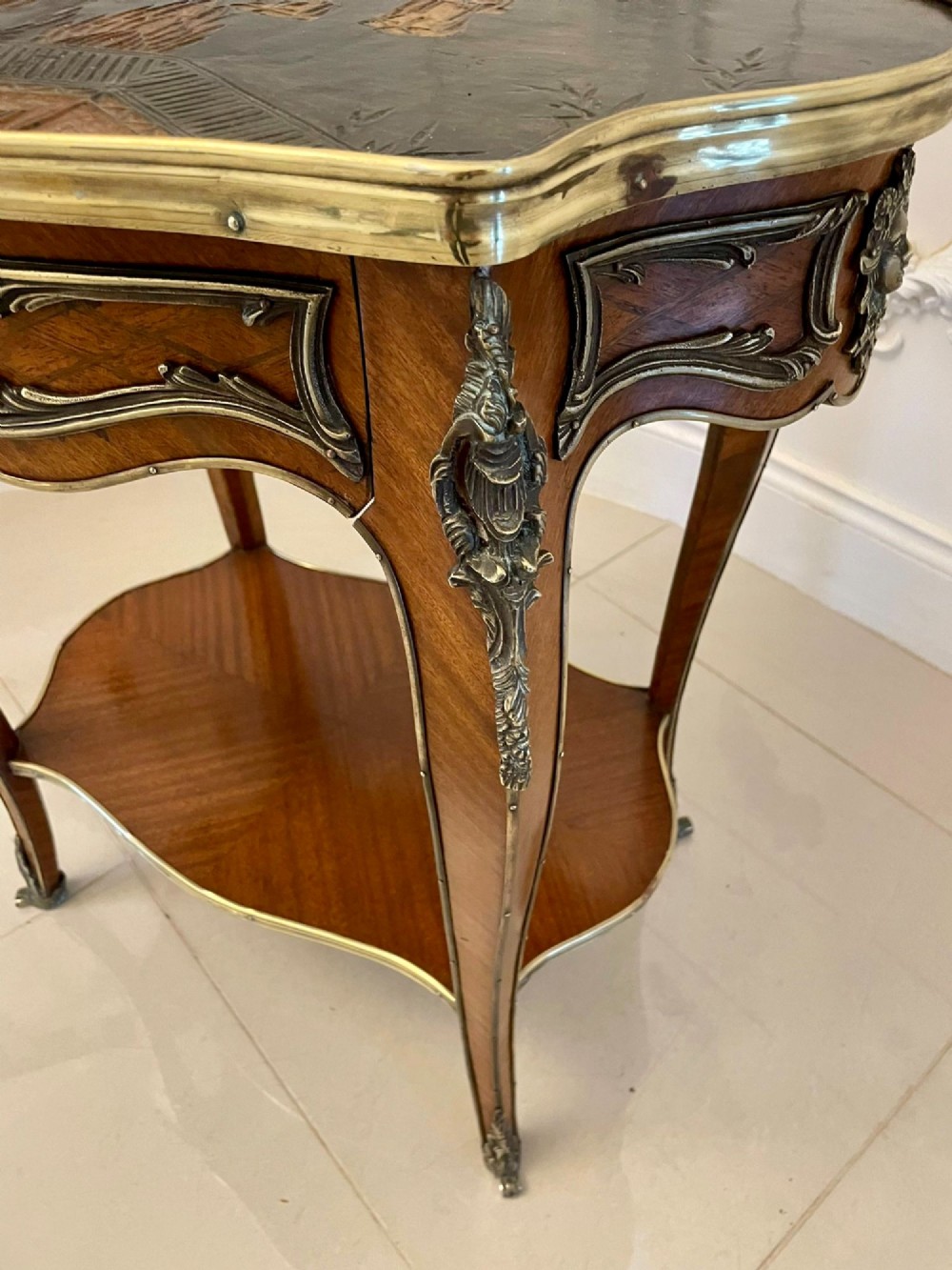 A nineteenth-century French kingwood centre table with serpentine edges, pictorial marquetry top, ormolu mounts, cabriole legs, and a lower shelf. View V