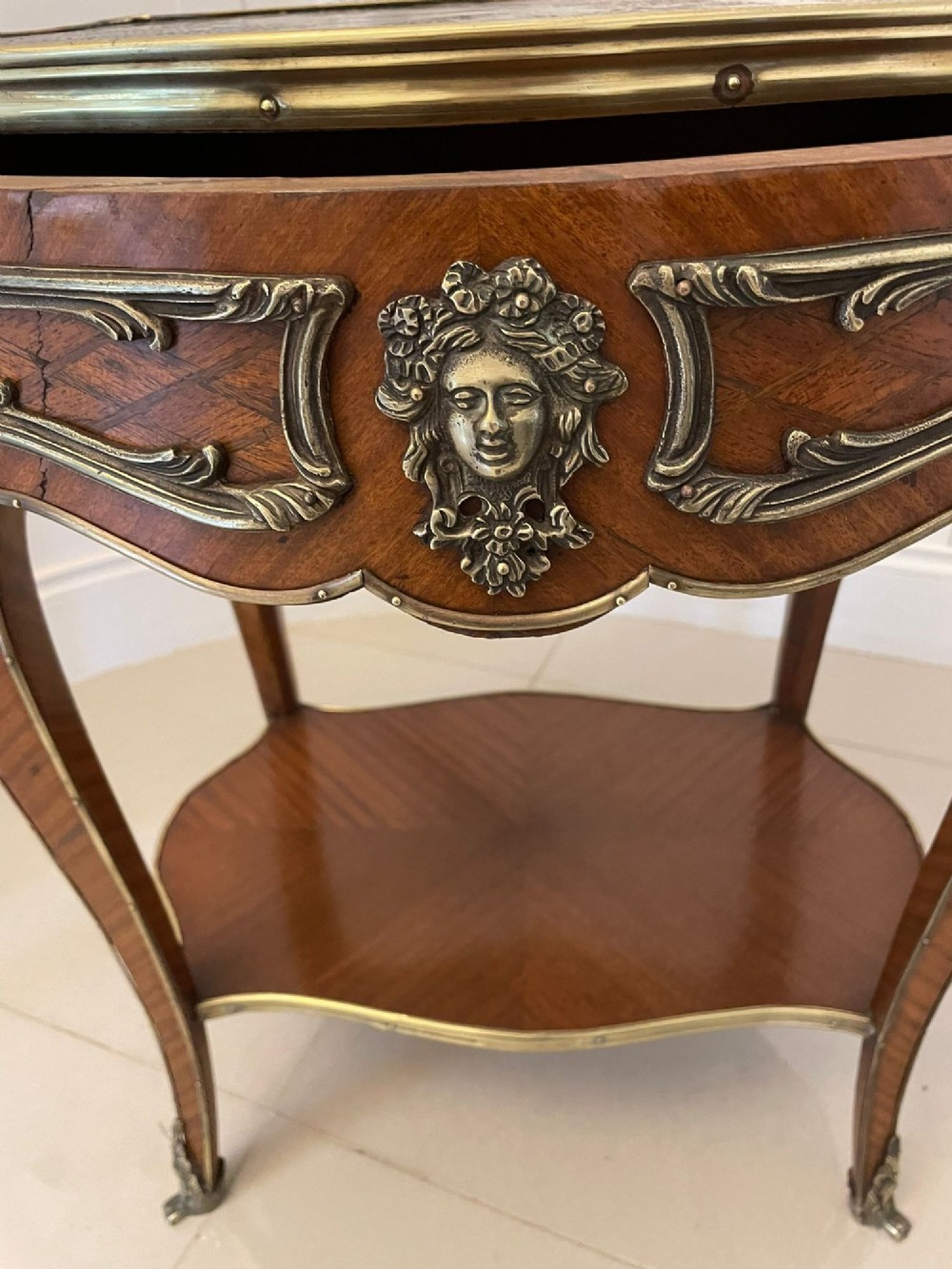 A nineteenth-century French kingwood centre table with serpentine edges, pictorial marquetry top, ormolu mounts, cabriole legs, and a lower shelf. View XIV