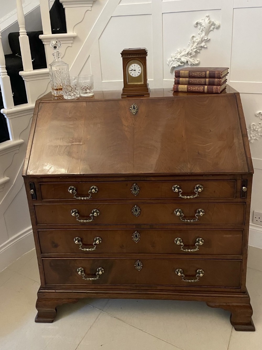An 18th-century George III mahogany bureau featuring a slant front writing slope above four graduated drawers with brass handles on bracket feet. View II