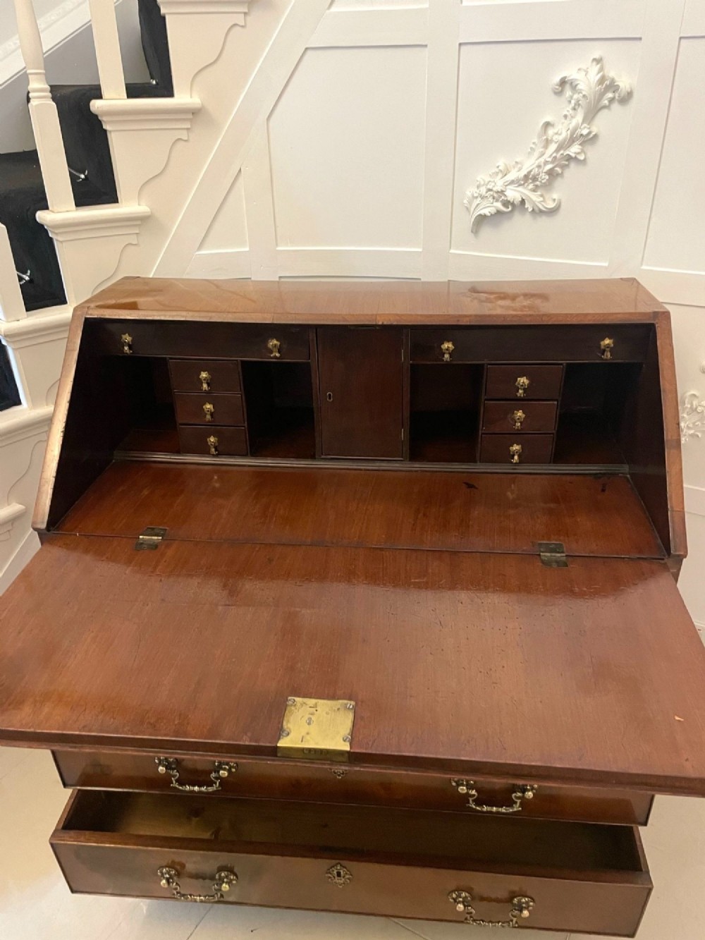 An 18th-century George III mahogany bureau featuring a slant front writing slope above four graduated drawers with brass handles on bracket feet. View III