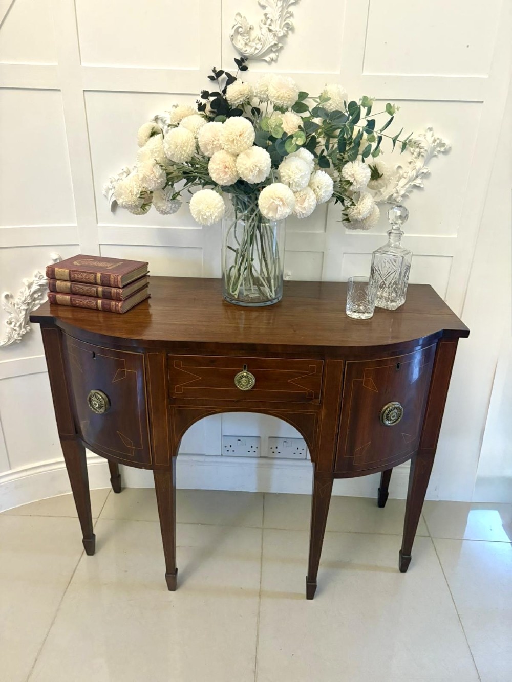 A George III mahogany sideboard featuring geometric boxwood stringing inlay, brass rosette handles, a central arch drawer, and square tapered legs. View II