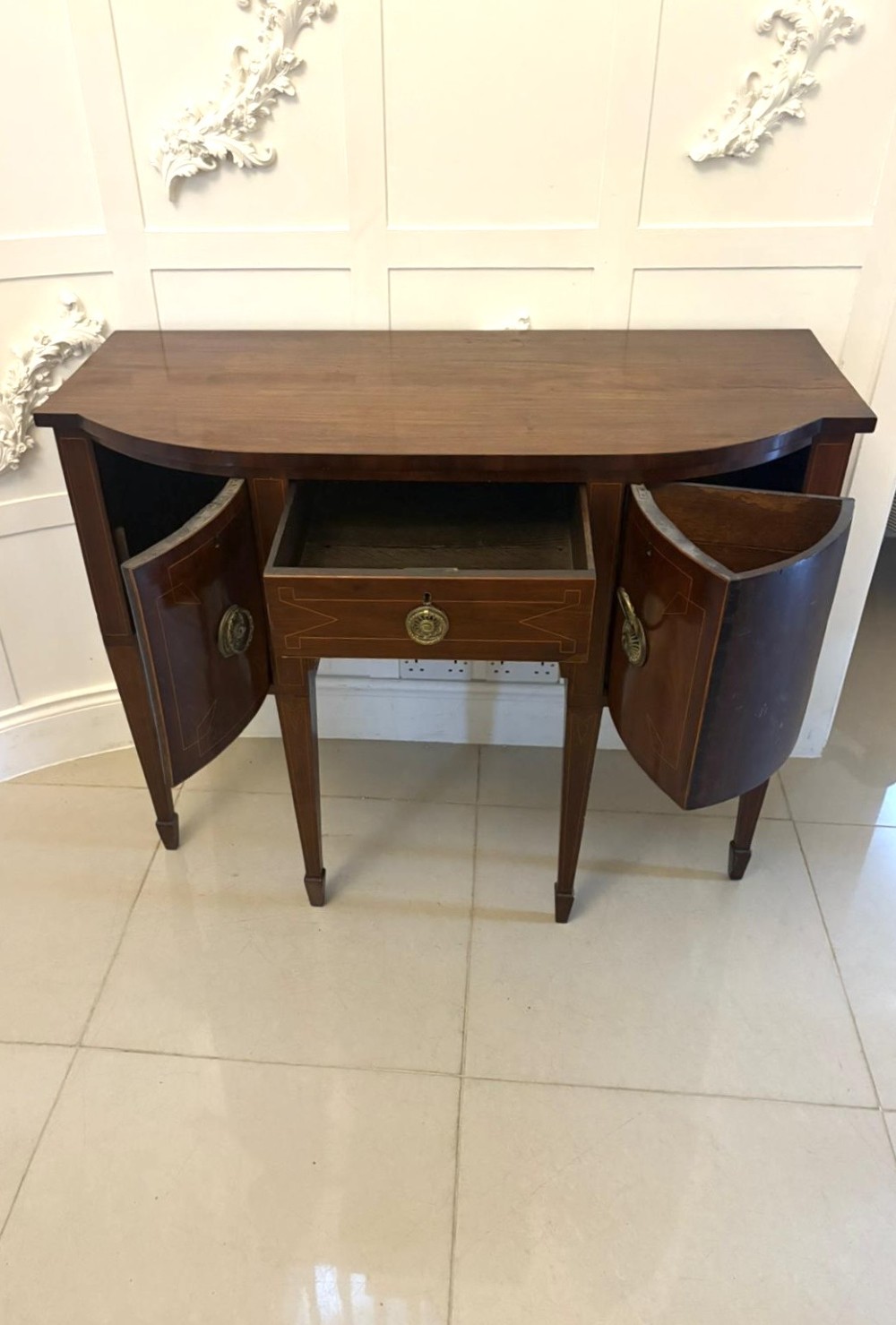 A George III mahogany sideboard featuring geometric boxwood stringing inlay, brass rosette handles, a central arch drawer, and square tapered legs. View V