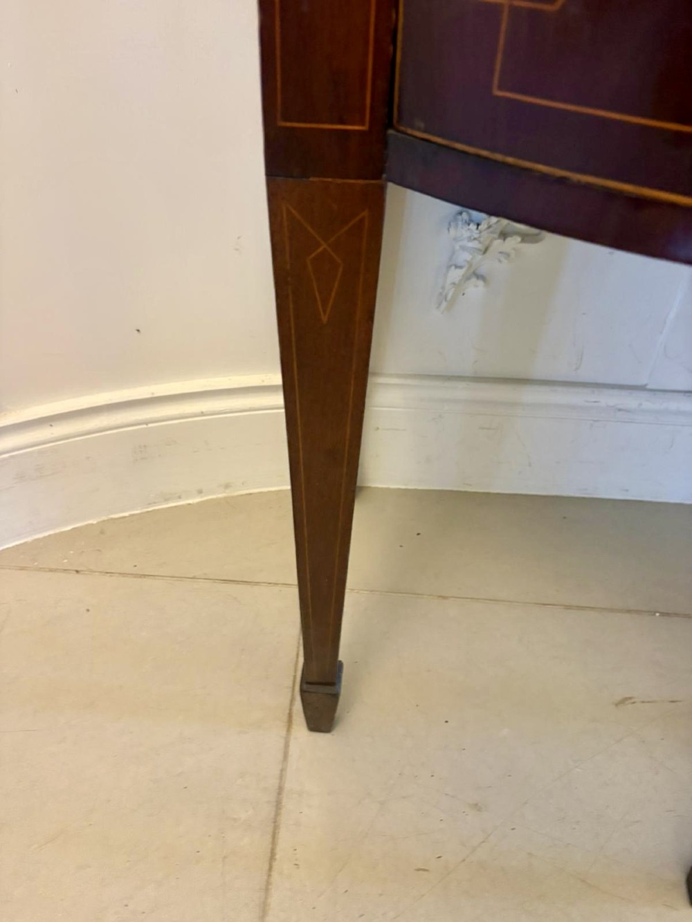 A George III mahogany sideboard featuring geometric boxwood stringing inlay, brass rosette handles, a central arch drawer, and square tapered legs. View VI