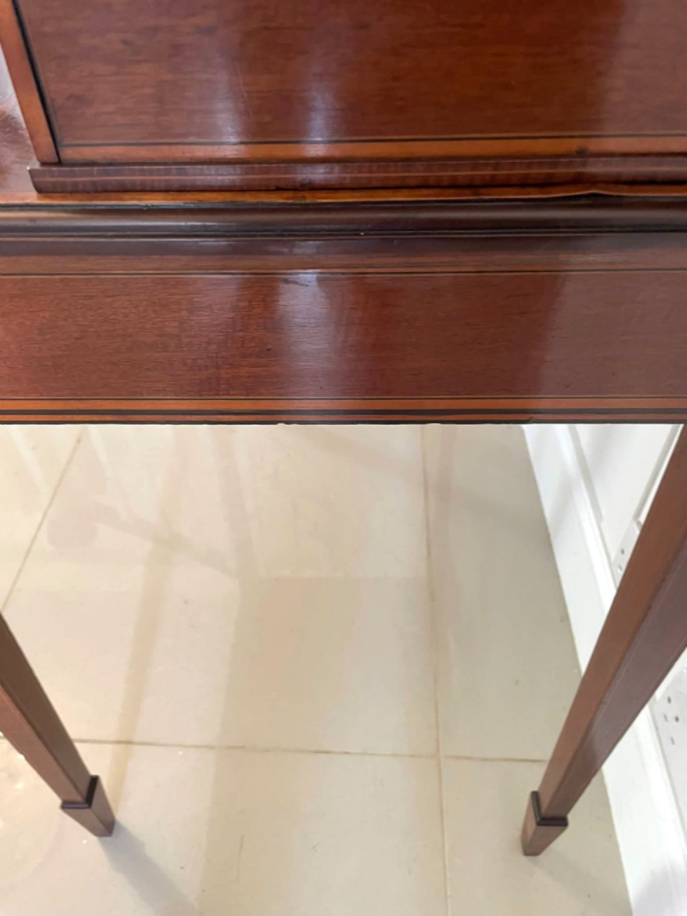 A Victorian inlaid mahogany writing desk featuring a brass gallery top, mirrored arched niche, floral marquetry cabinets, small drawers, and tapered square legs. View IV