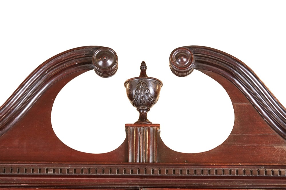 A Victorian mahogany breakfront display cabinet with astragal glazed doors, open side shelves, and a swan-neck pediment topped with an urn finial. View II
