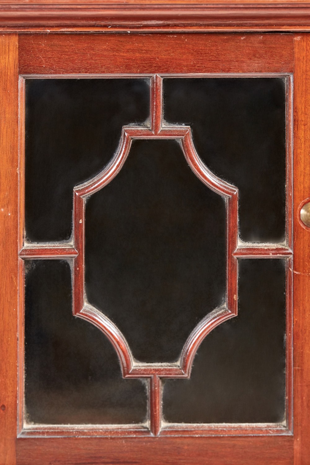 A Victorian mahogany breakfront display cabinet with astragal glazed doors, open side shelves, and a swan-neck pediment topped with an urn finial. View VII