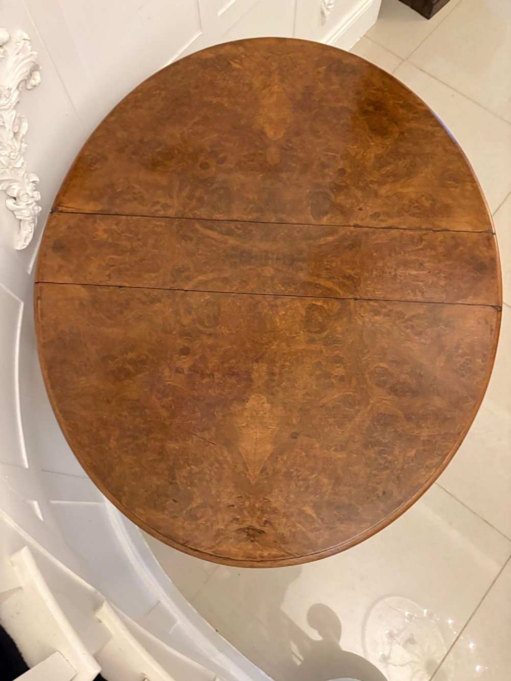 A folded Victorian burr walnut Sutherland table featuring turned upright supports, a stretcher base, and white ceramic castors. View VIII
