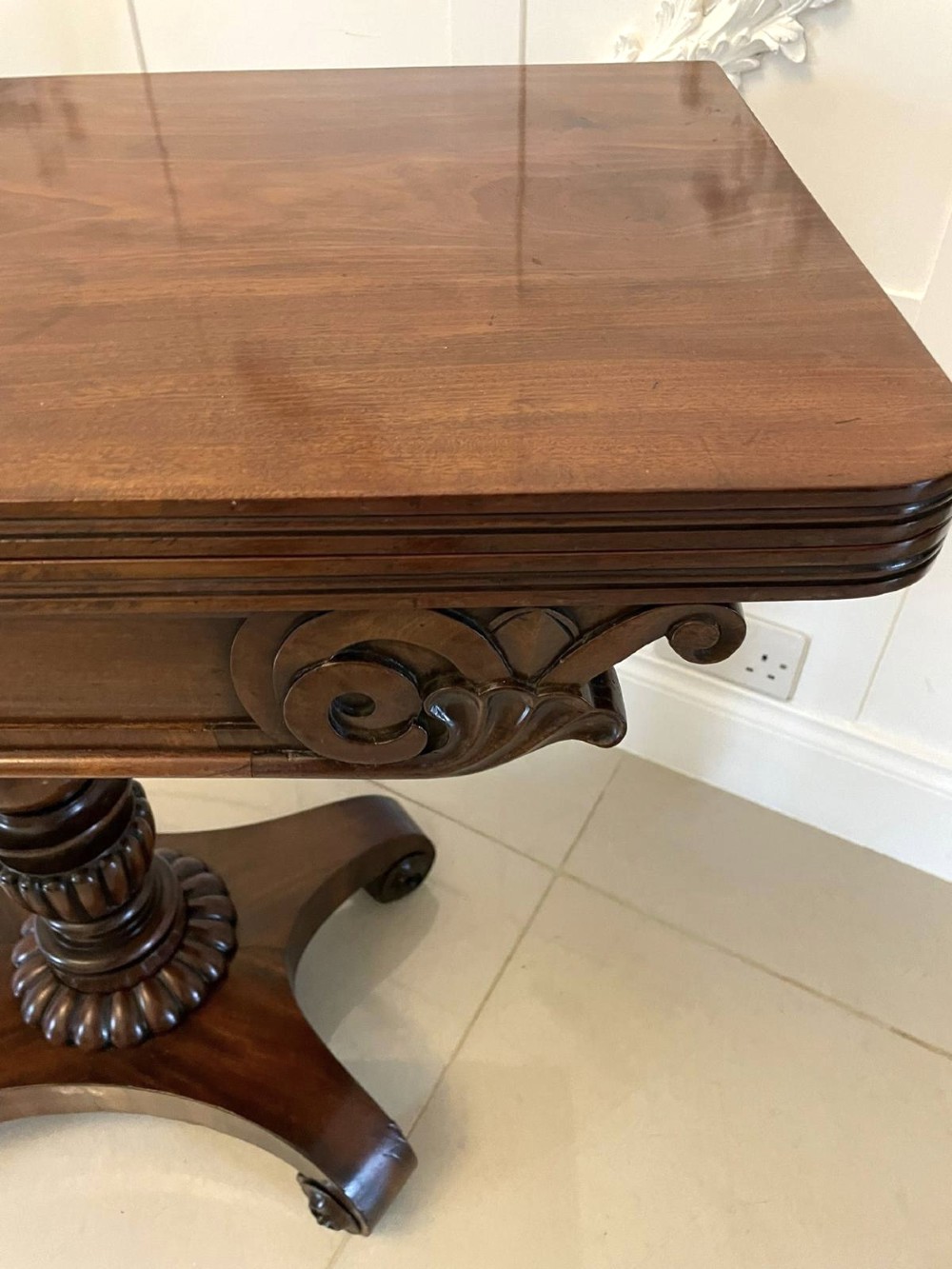 A William IV mahogany fold-over tea table with a turned gadrooned pedestal stem and a concave quadform base ending in scroll feet. View VIII