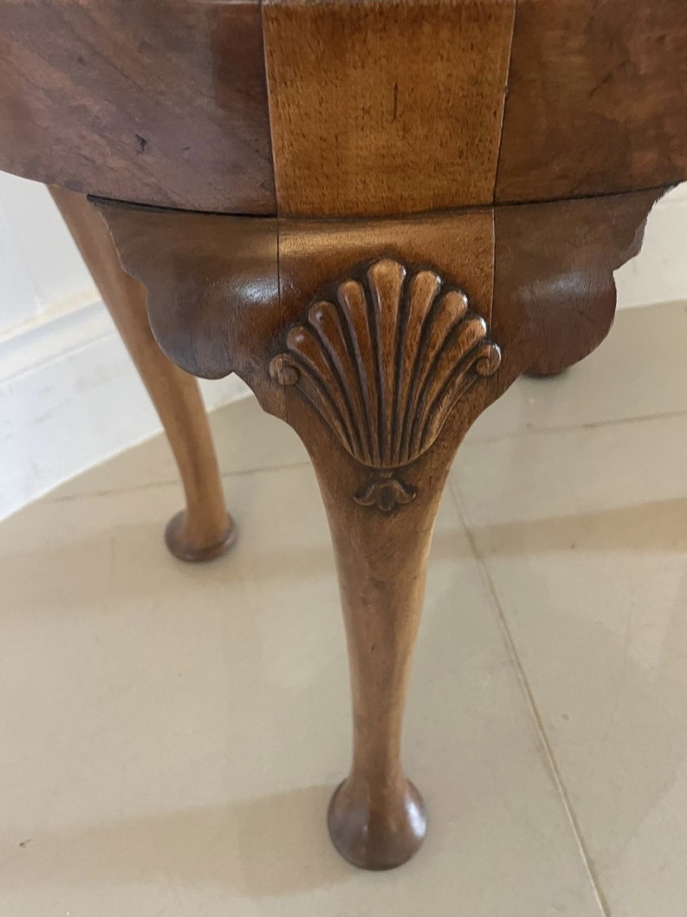 An antique oval walnut stool featuring shell-carved cabriole legs, pad feet, and a geometric pattern upholstered seat. View VI