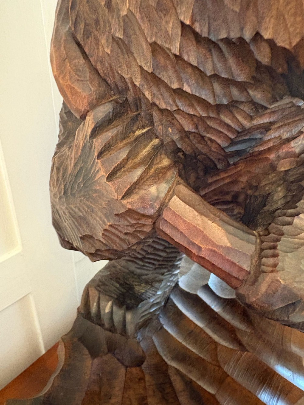 A hand-carved dark linden wood sculpture depicting a roaring bear carrying a fish over its back, positioned on a carved textured base. View II