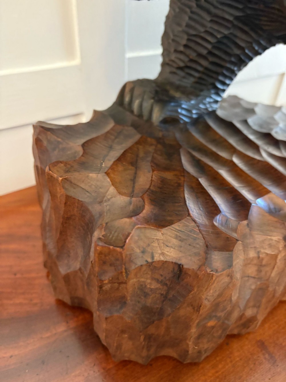 A hand-carved dark linden wood sculpture depicting a roaring bear carrying a fish over its back, positioned on a carved textured base. View X