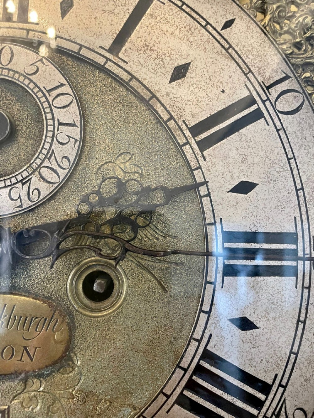 A George III mahogany longcase clock featuring an arched brass dial, urn finials, and an arched trunk door. View VIII