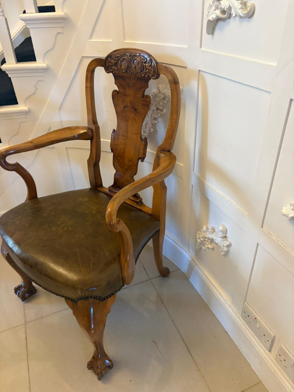 A set of six carved walnut dining chairs featuring decorative back splats, leather seats with brass studs, cabriole legs, and ball and claw feet. View IX