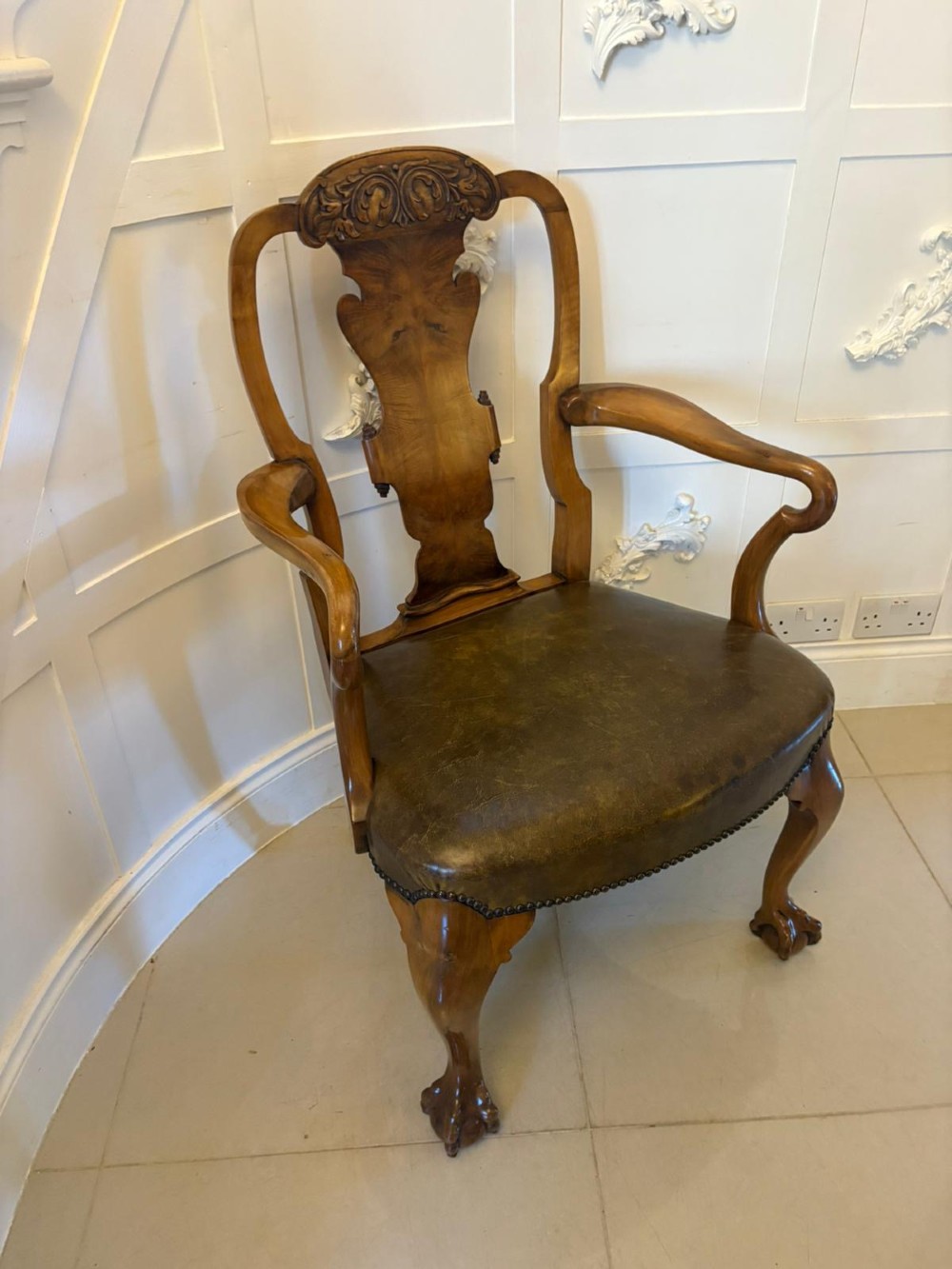 A set of six carved walnut dining chairs featuring decorative back splats, leather seats with brass studs, cabriole legs, and ball and claw feet. View XI